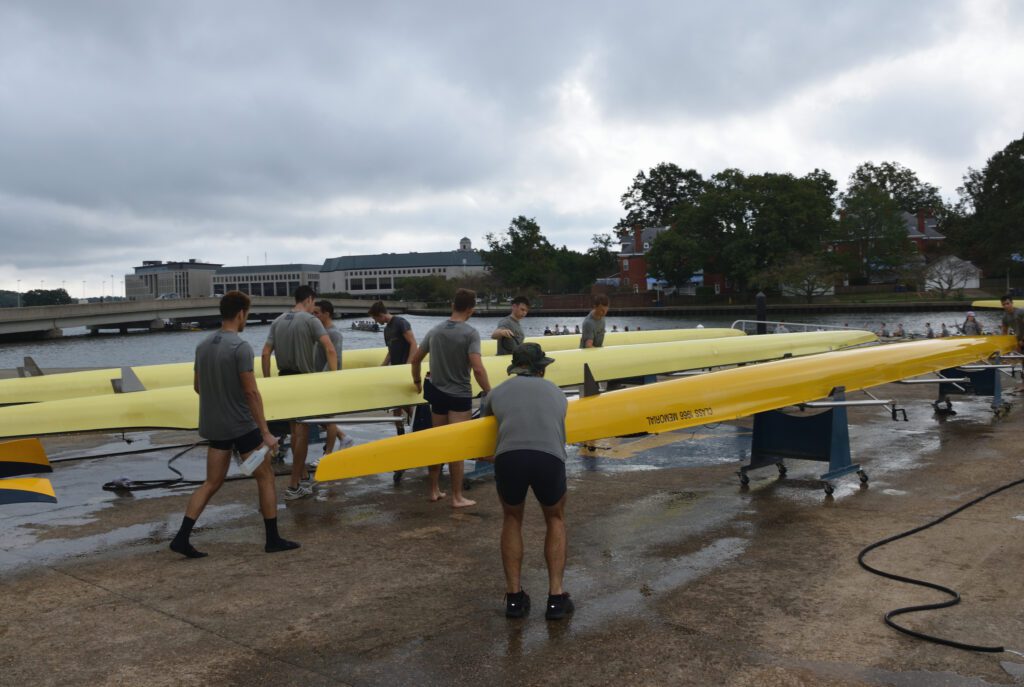 The Navy Lightweight Rowing team details the crew shells after practice. 